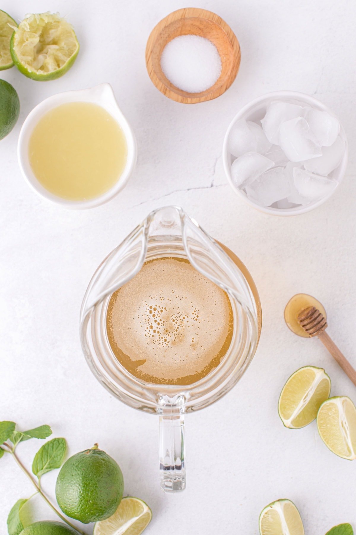 limeade in a pitcher with the rest of the limeade recipe ingredients next to it