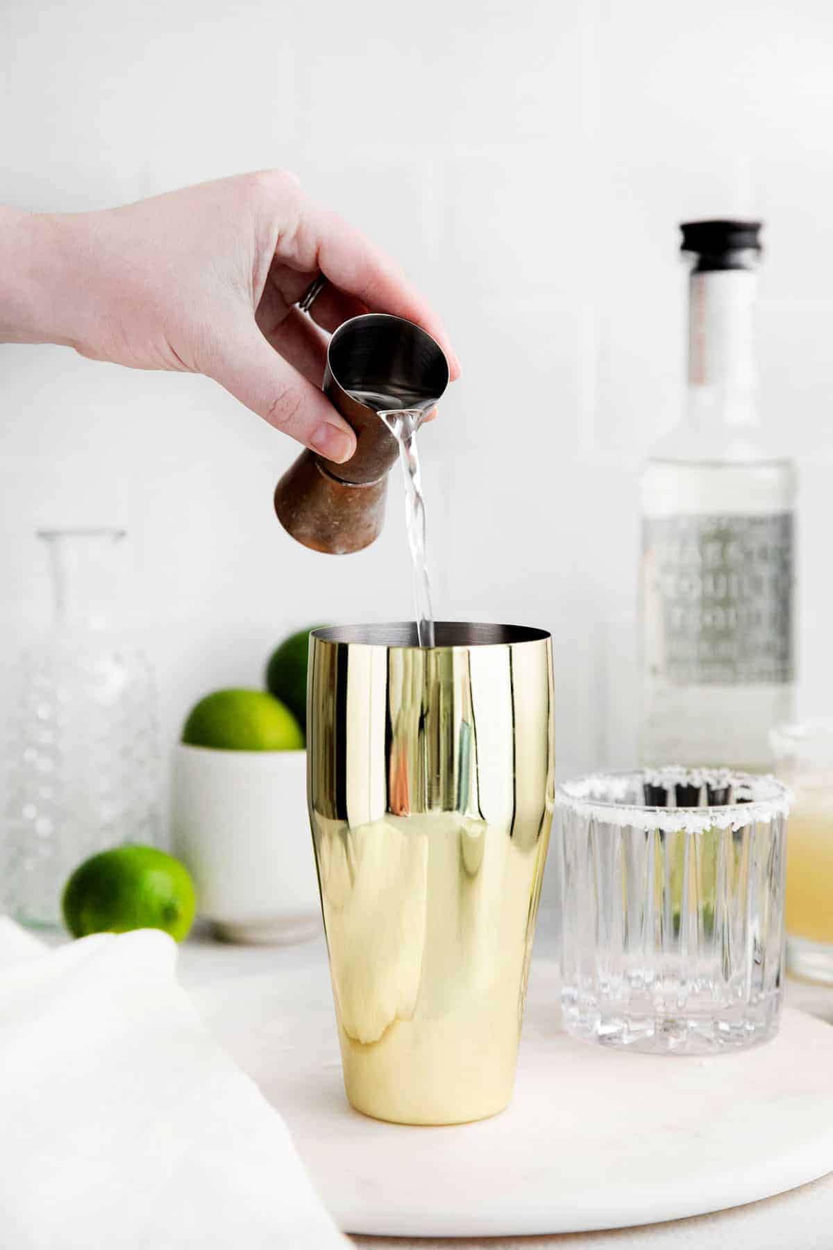 Tequila being poured into a cocktail shaker 