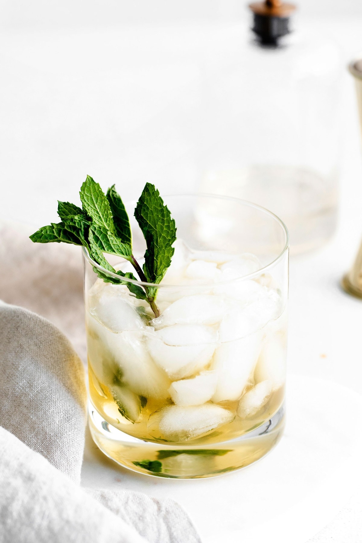 mint julep in a low ball glass garnished with fresh mint.