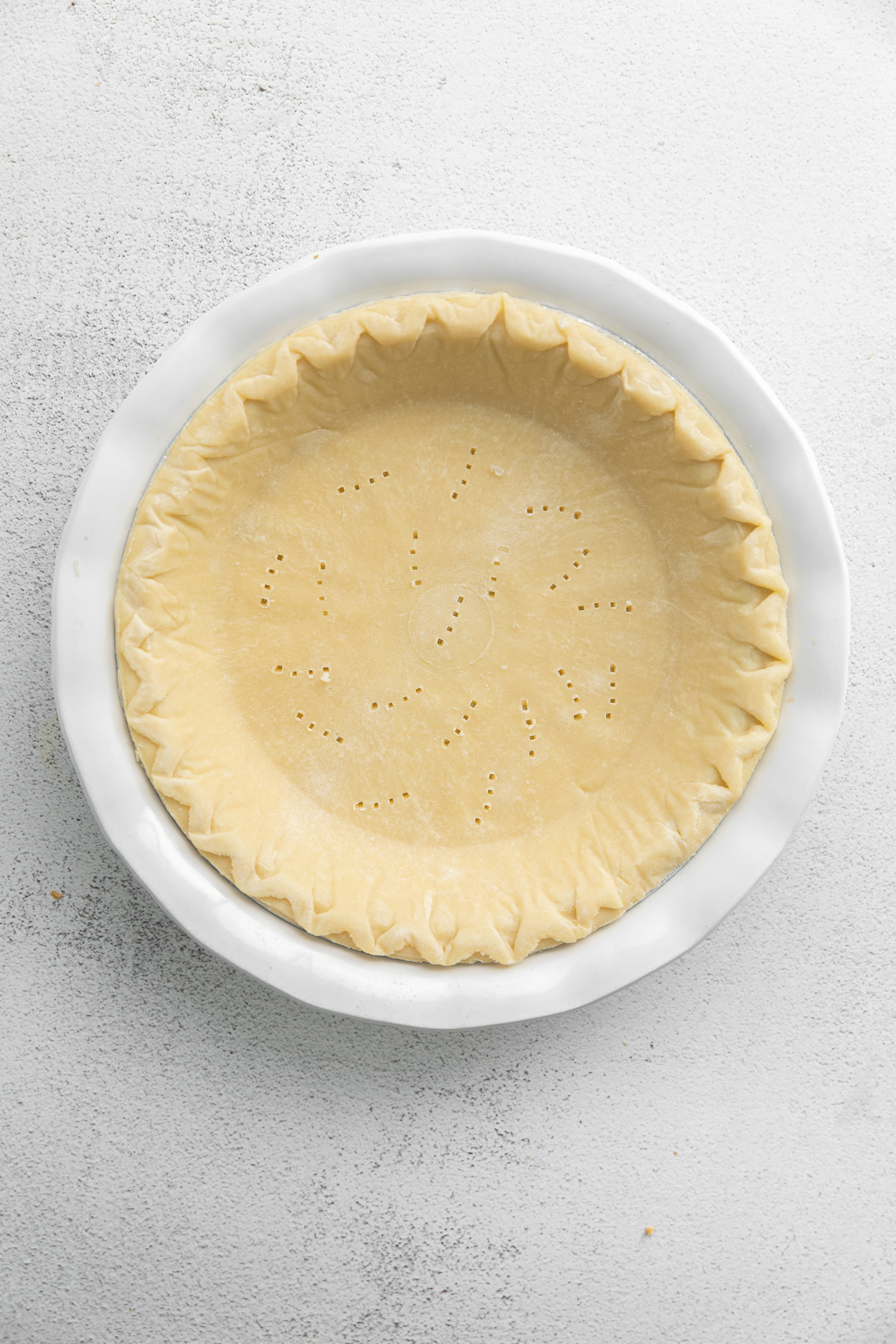 Quiche crust with holes in the bottom. 