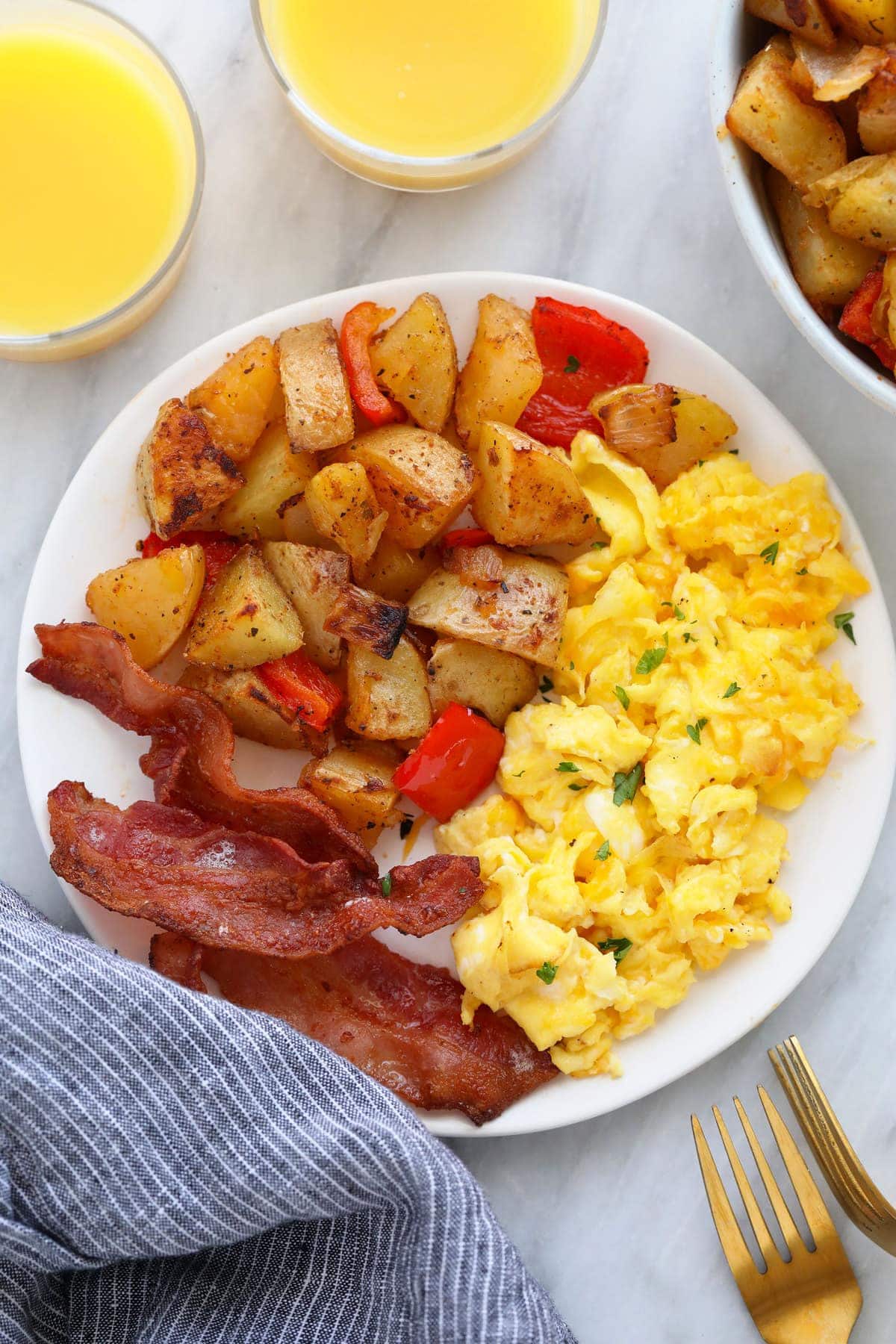 the best breakfast potatoes on a plate with eggs and bacon