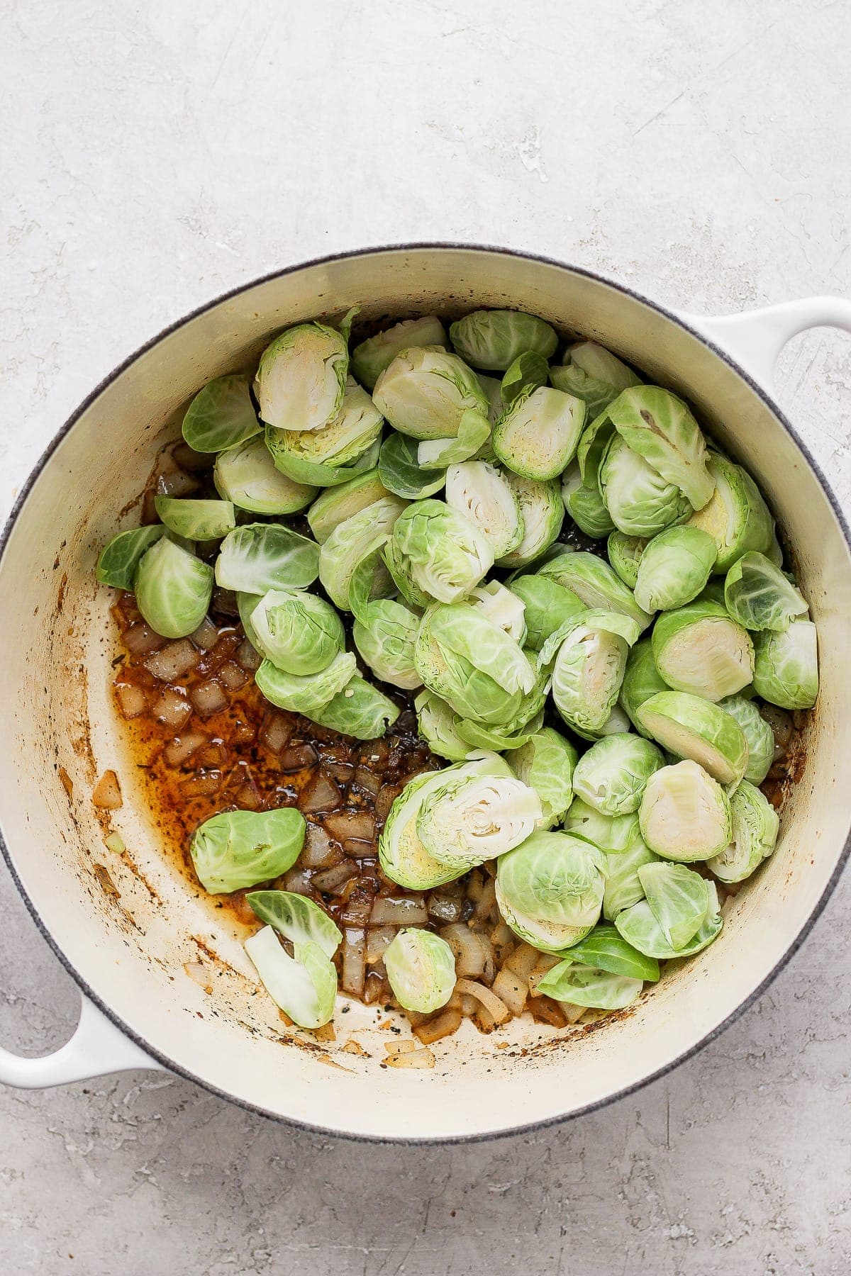 uncooked Brussels sprouts and onion in Dutch oven