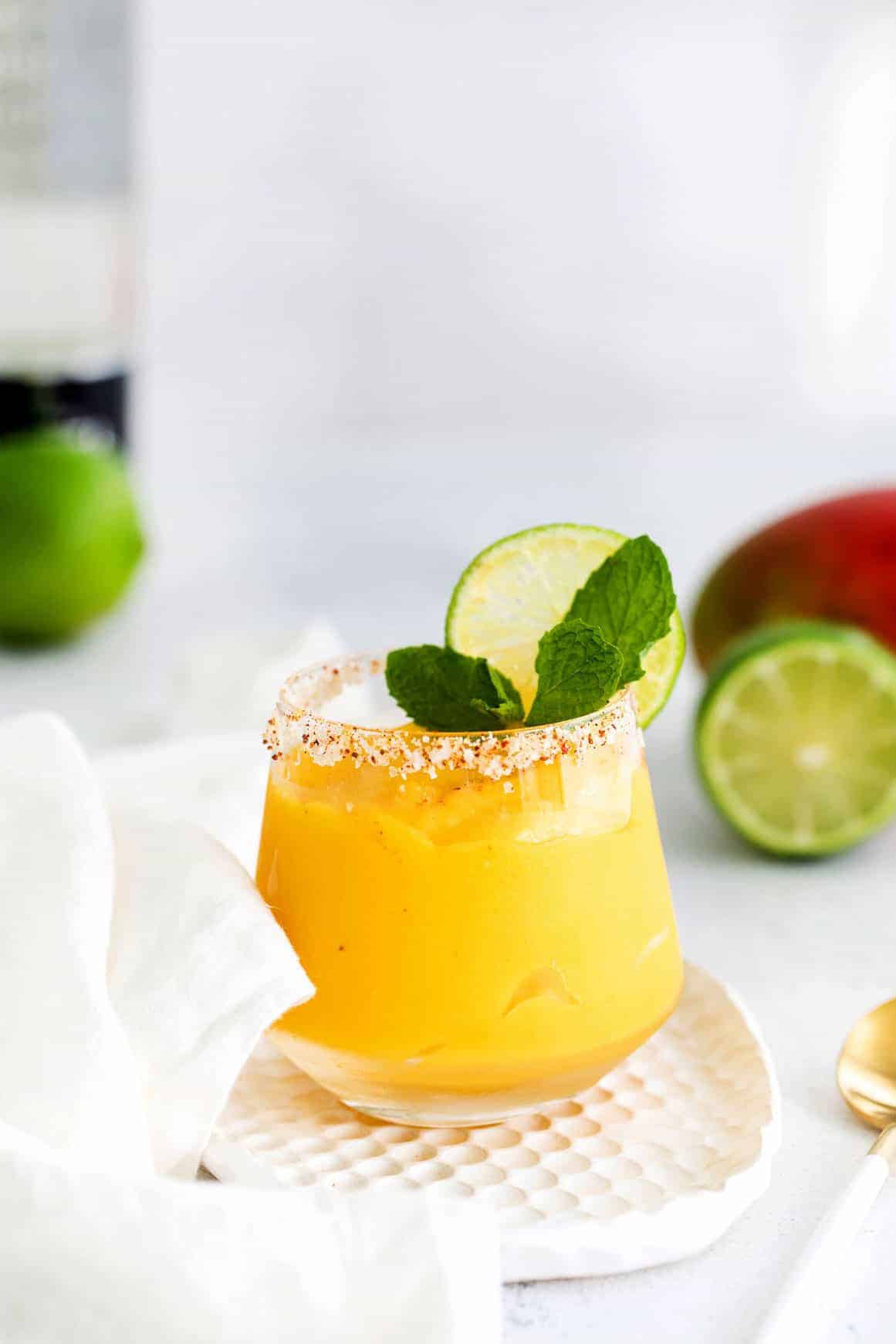 mango margarita in glass with mint.