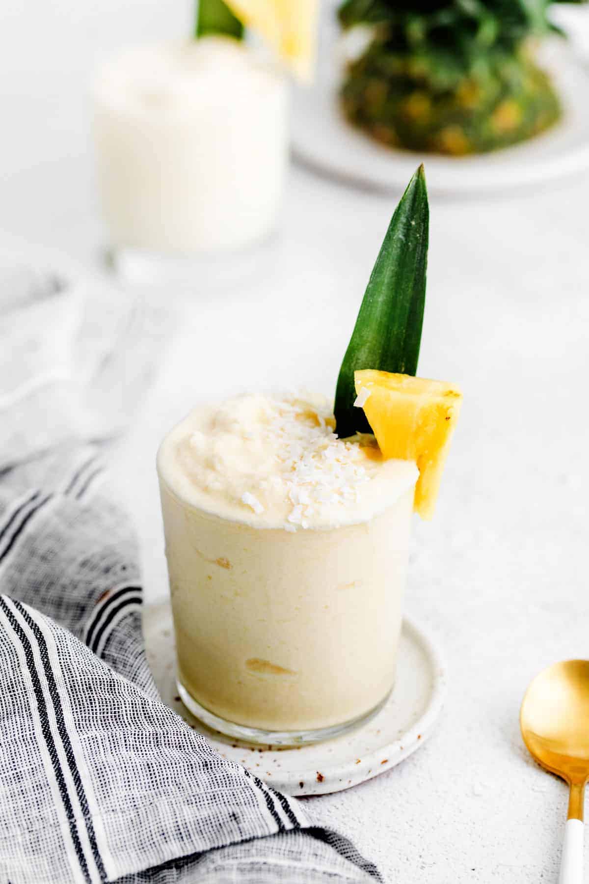 piña colada in glass with pineapple chunk