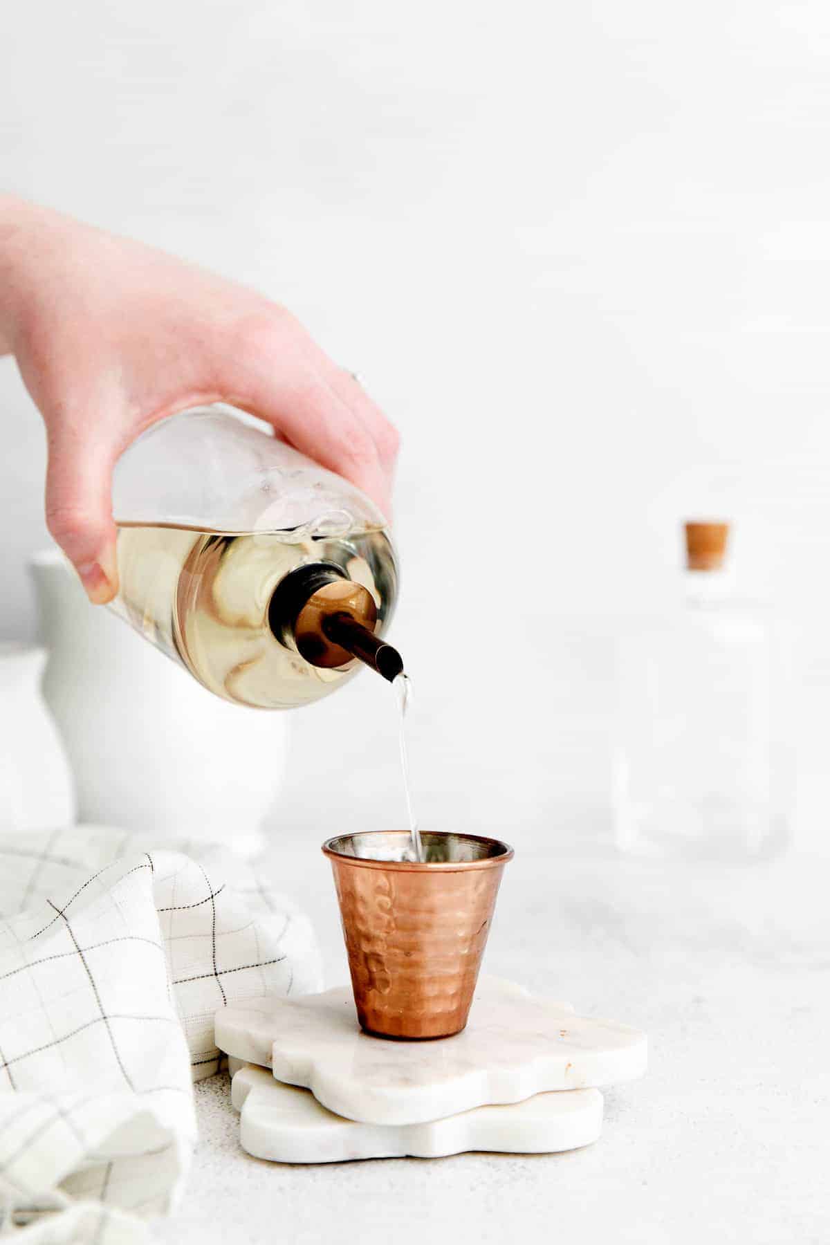 pouring simple syrup into shot glass