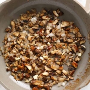 A skillet filled with mushrooms and onions, perfect for beef stroganoff.