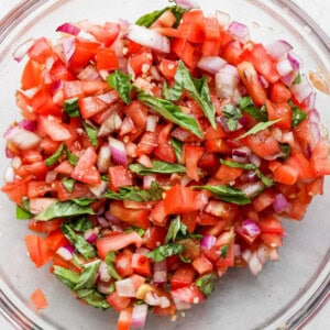 a glass bowl filled with chopped up vegetables.