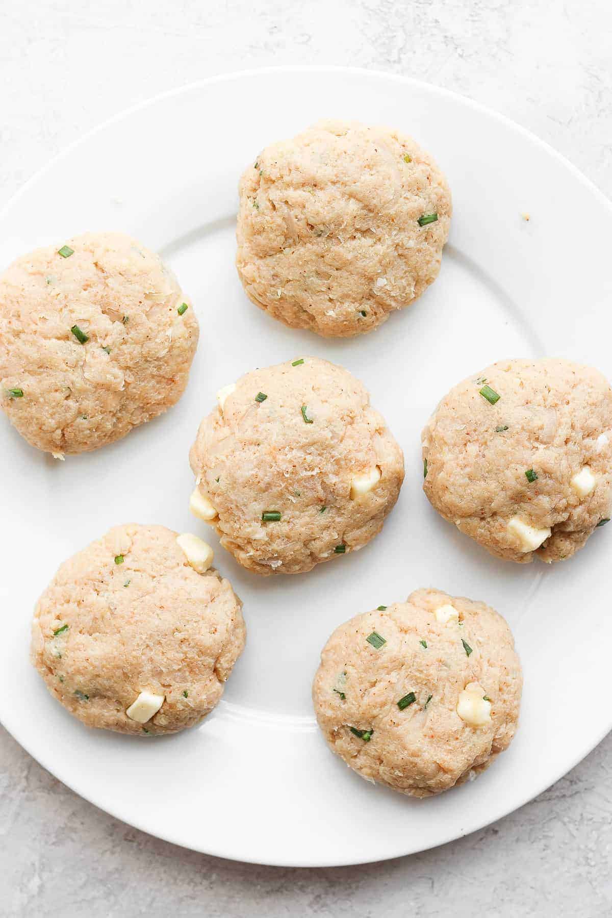 ground chicken burger patties on plate.