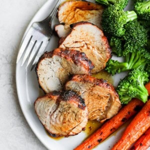 Grilled pork tenderloin served with vegetables.