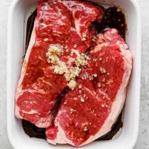 steak marinading in dish.