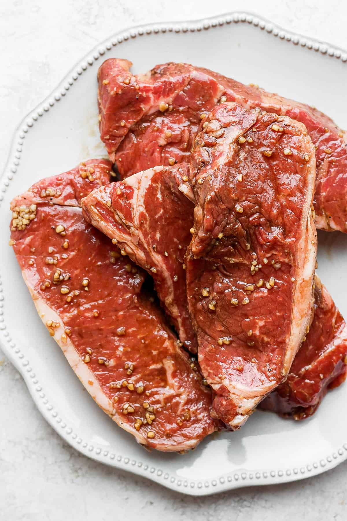 marinated steaks on plate.