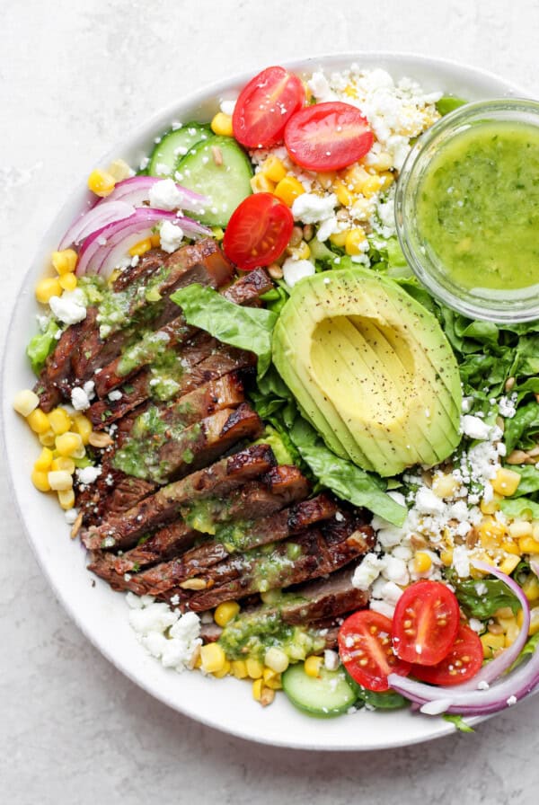 steak salad in bowl with dressing