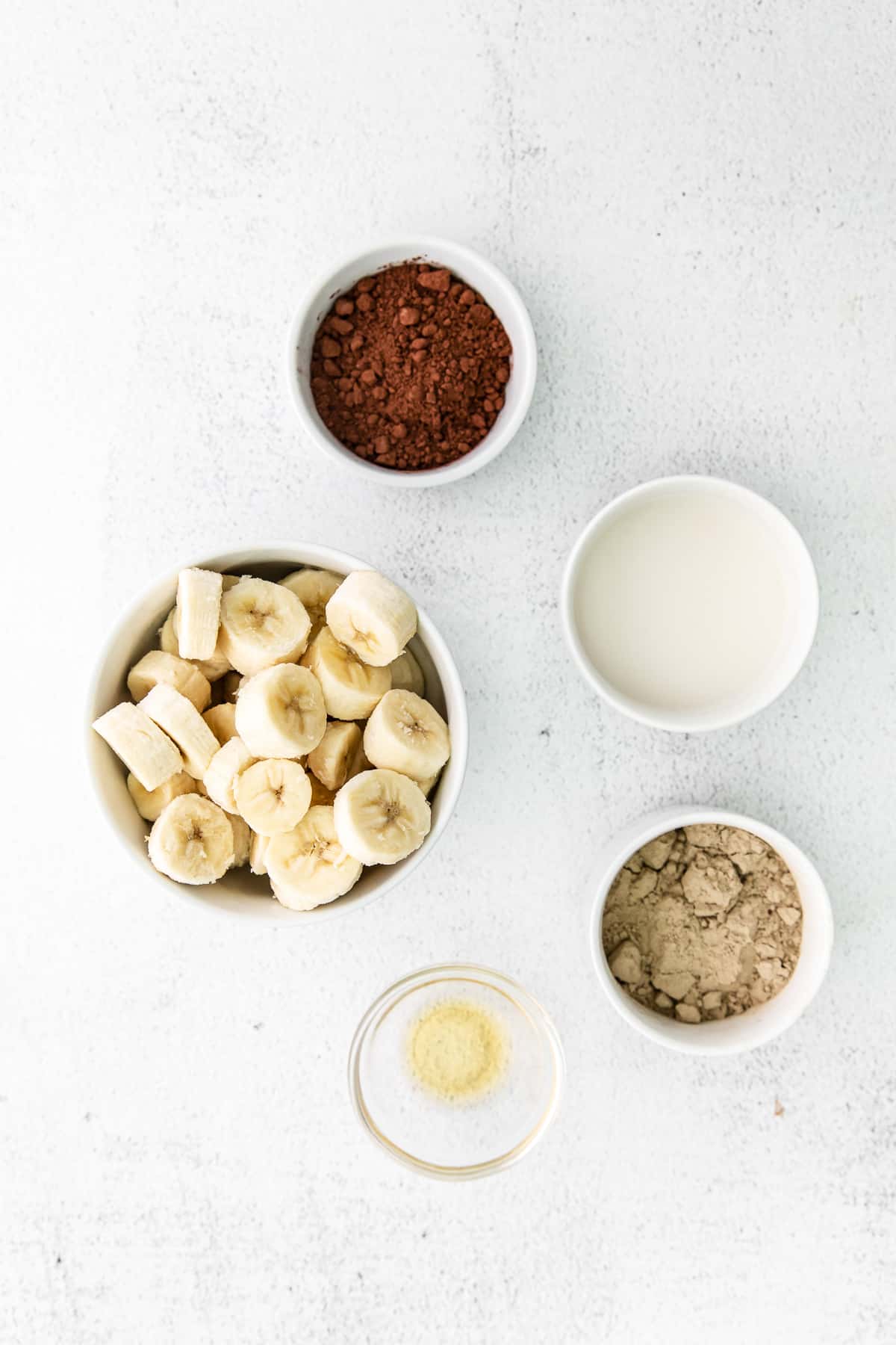 All the ingredients for protein ice cream in small bowls.