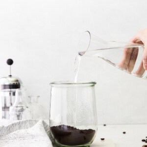 Pouring water over coffee grounds to make cold brew coffee.