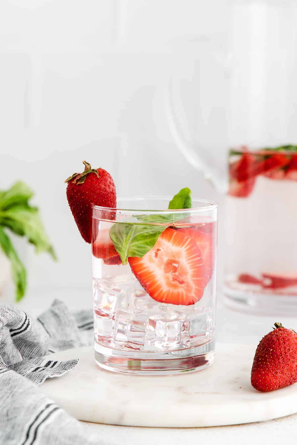 Strawberry and basil infused water in a glass.