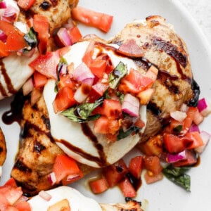 a white plate topped with meat covered in toppings.