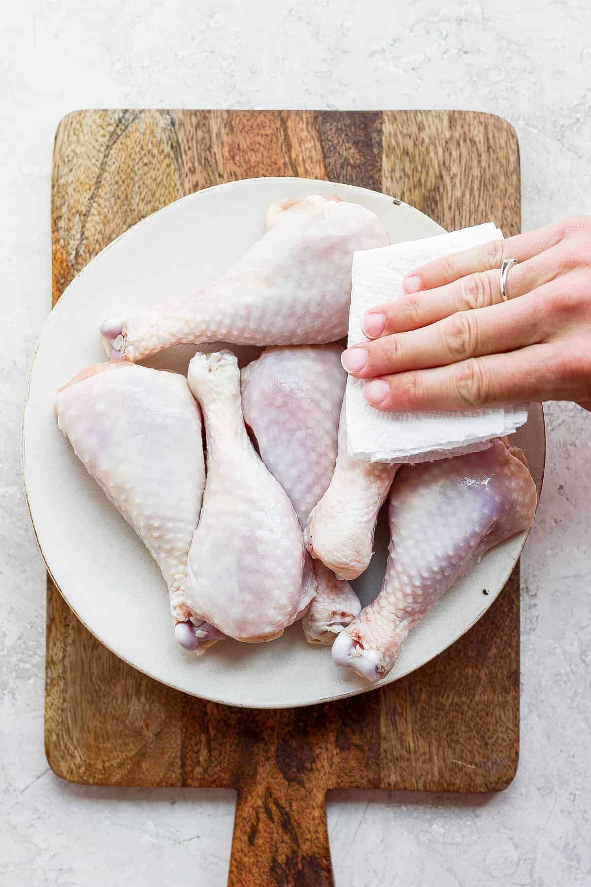 patting chicken legs with paper towel