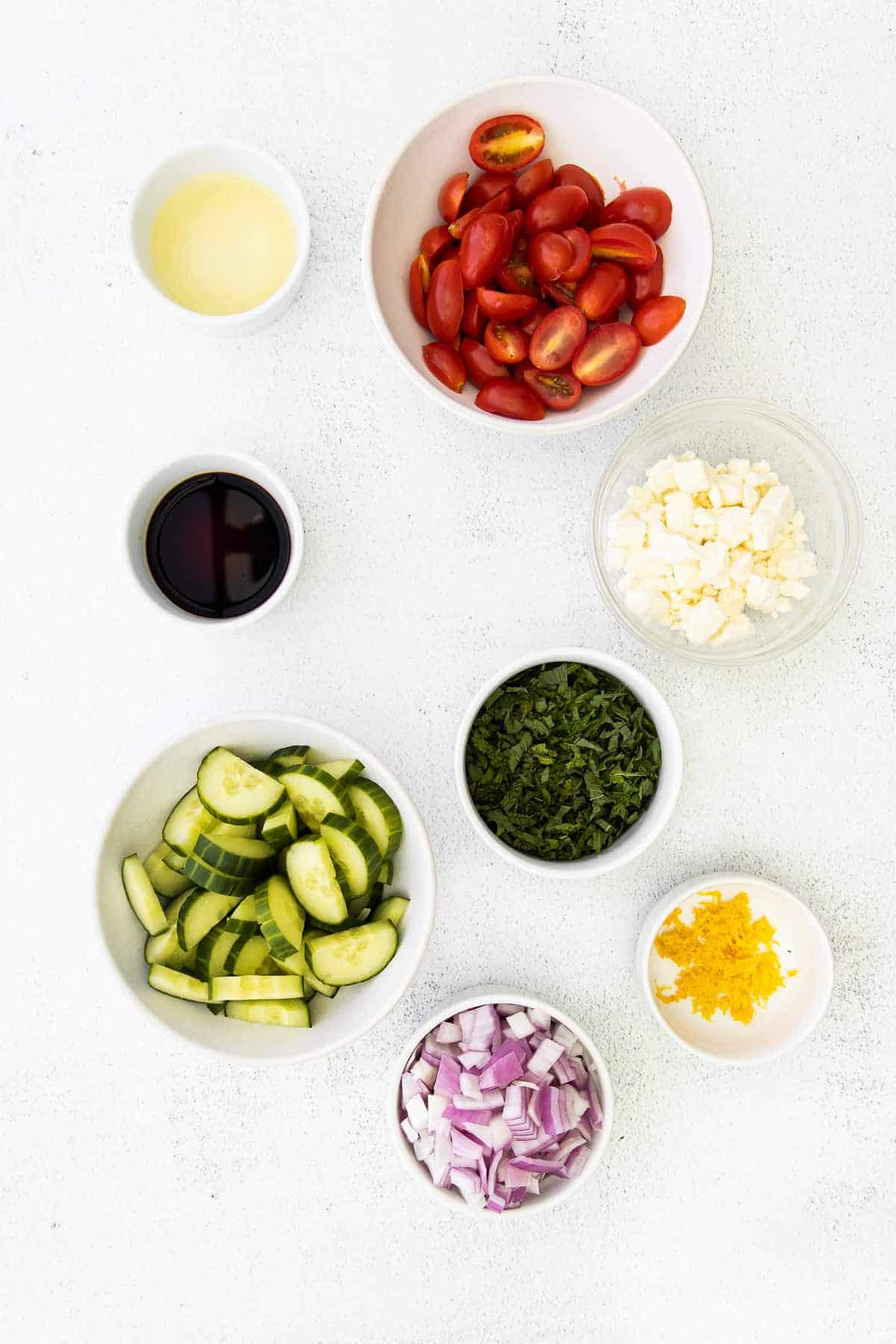 ingredients for mediterranean couscous salad in small bowls ready to be mixed together