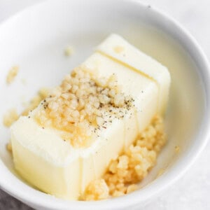 a white bowl with a piece of butter.