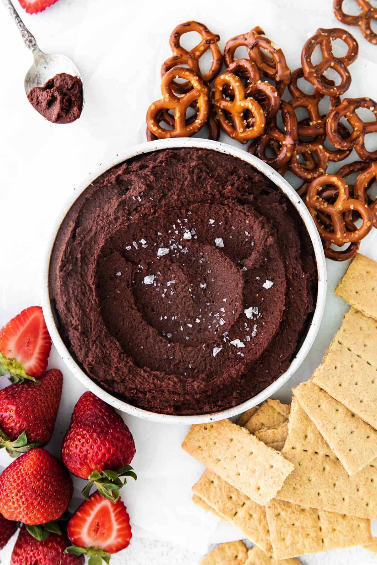 hummus in bowl with pretzels, graham crackers, and strawberries