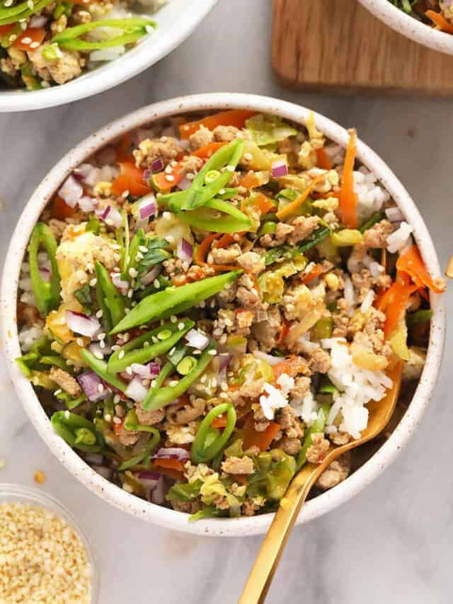 A bowl of asian stir fry with rice and vegetables.