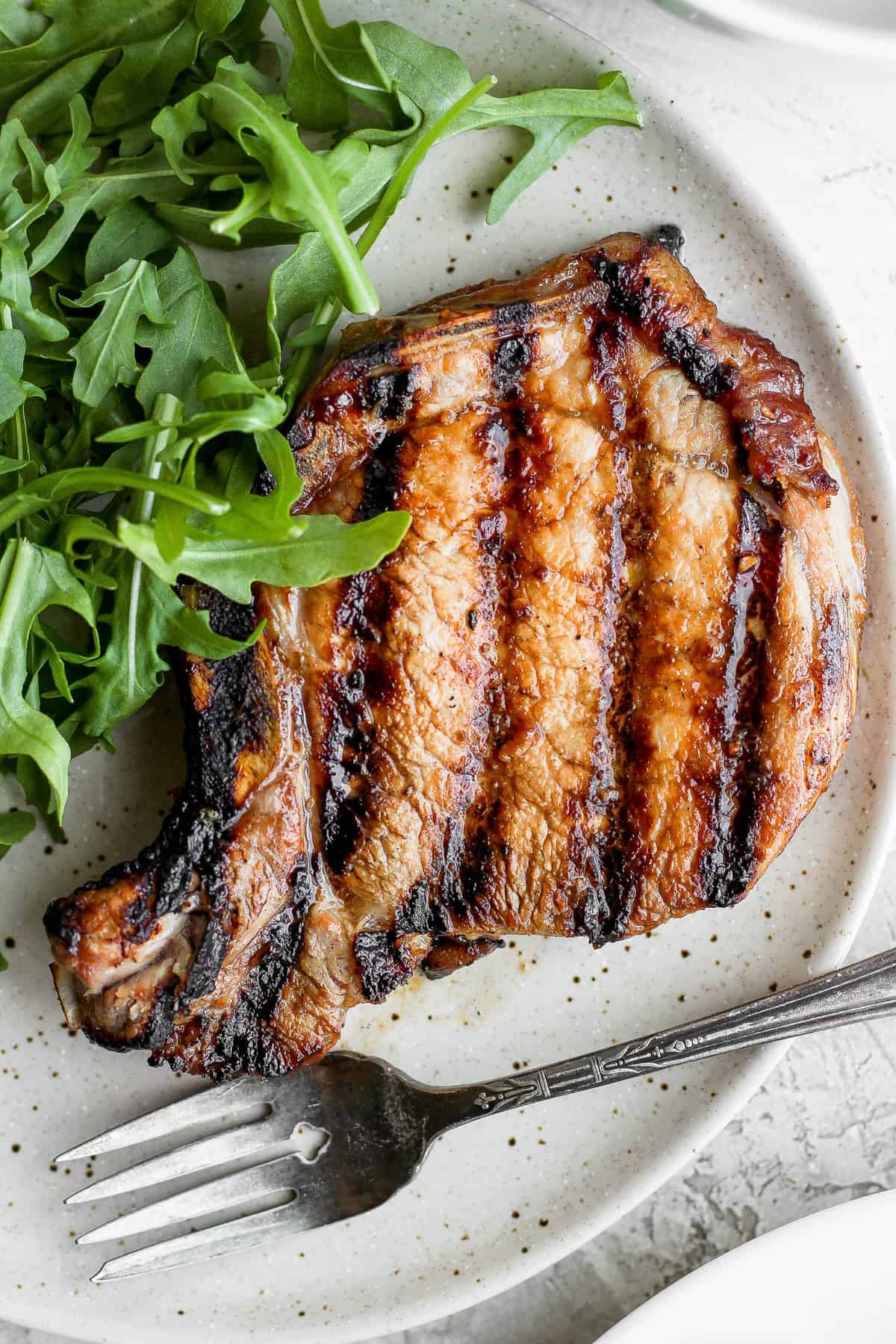 grilled pork chop on plate.