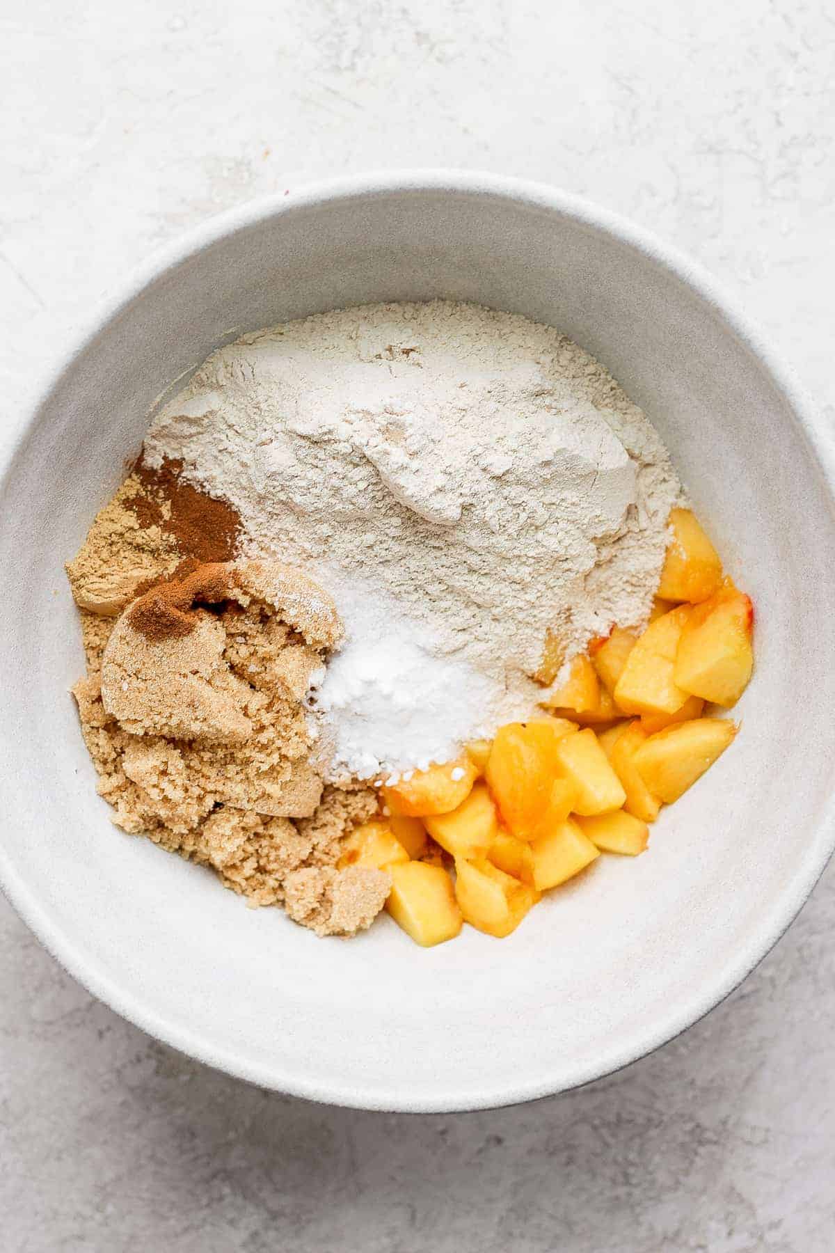 peach muffin ingredients in a bowl ready to be mixed together