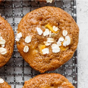 a cooling rack with peach muffins and almonds on it.