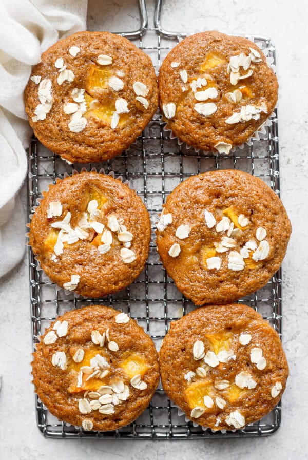 Peach muffins on a cooling rack.