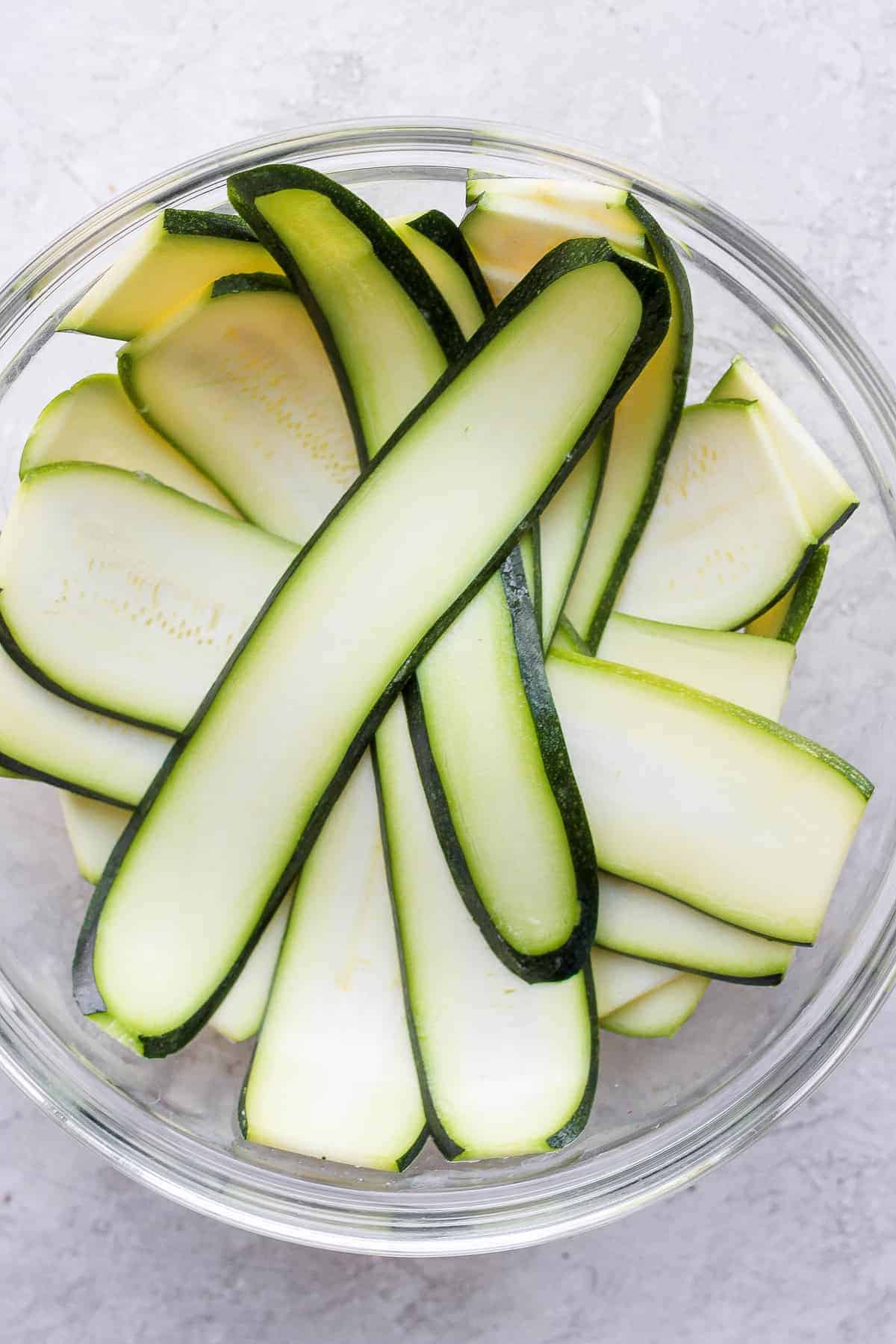 zucchini sliced by a mandolin in a bowl