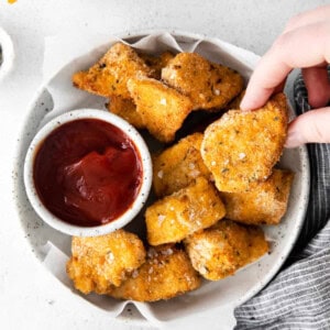 chicken nuggets in a bowl with ketchup.