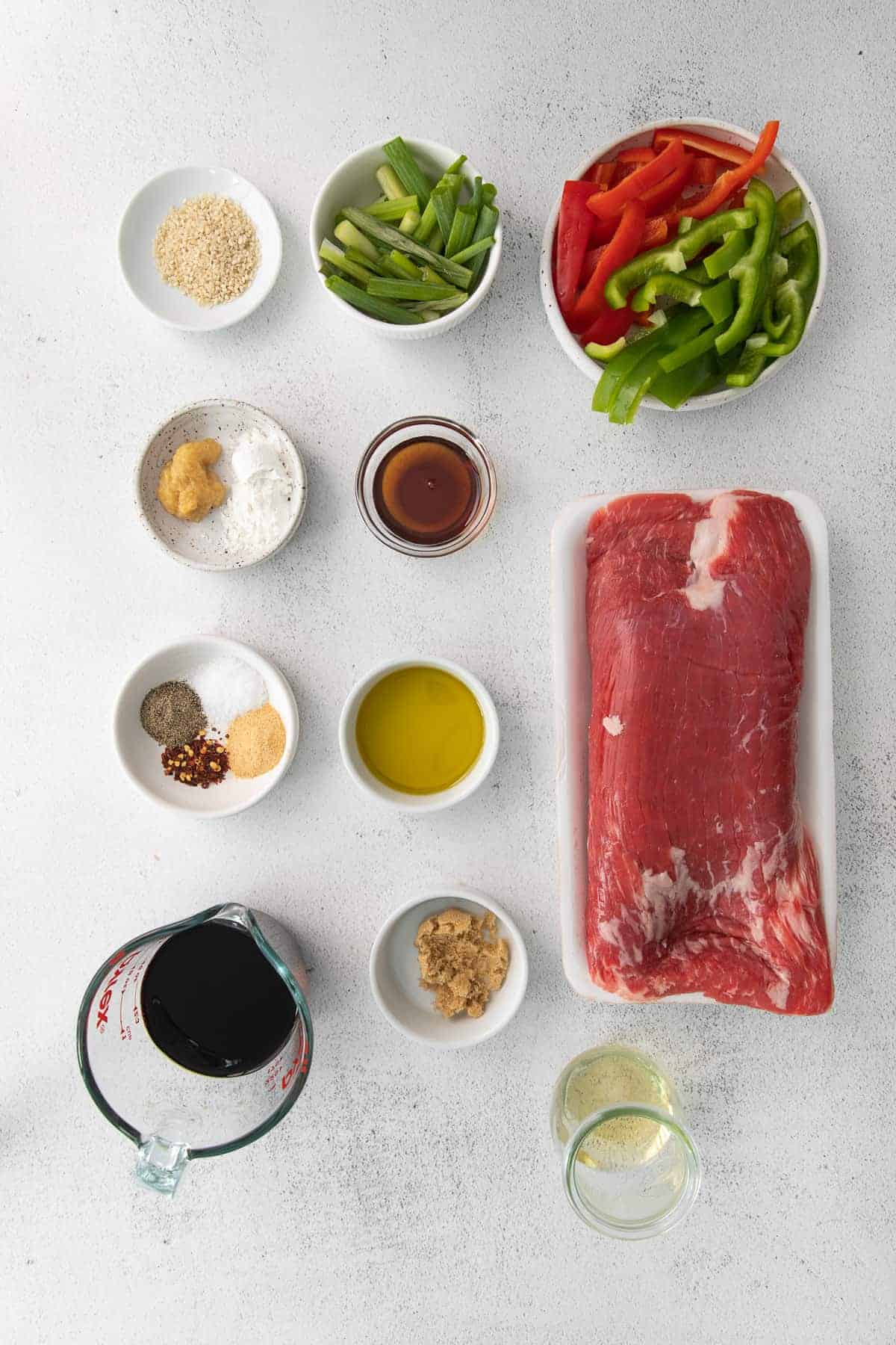 all the ingredients for pepper steak in small bowls.