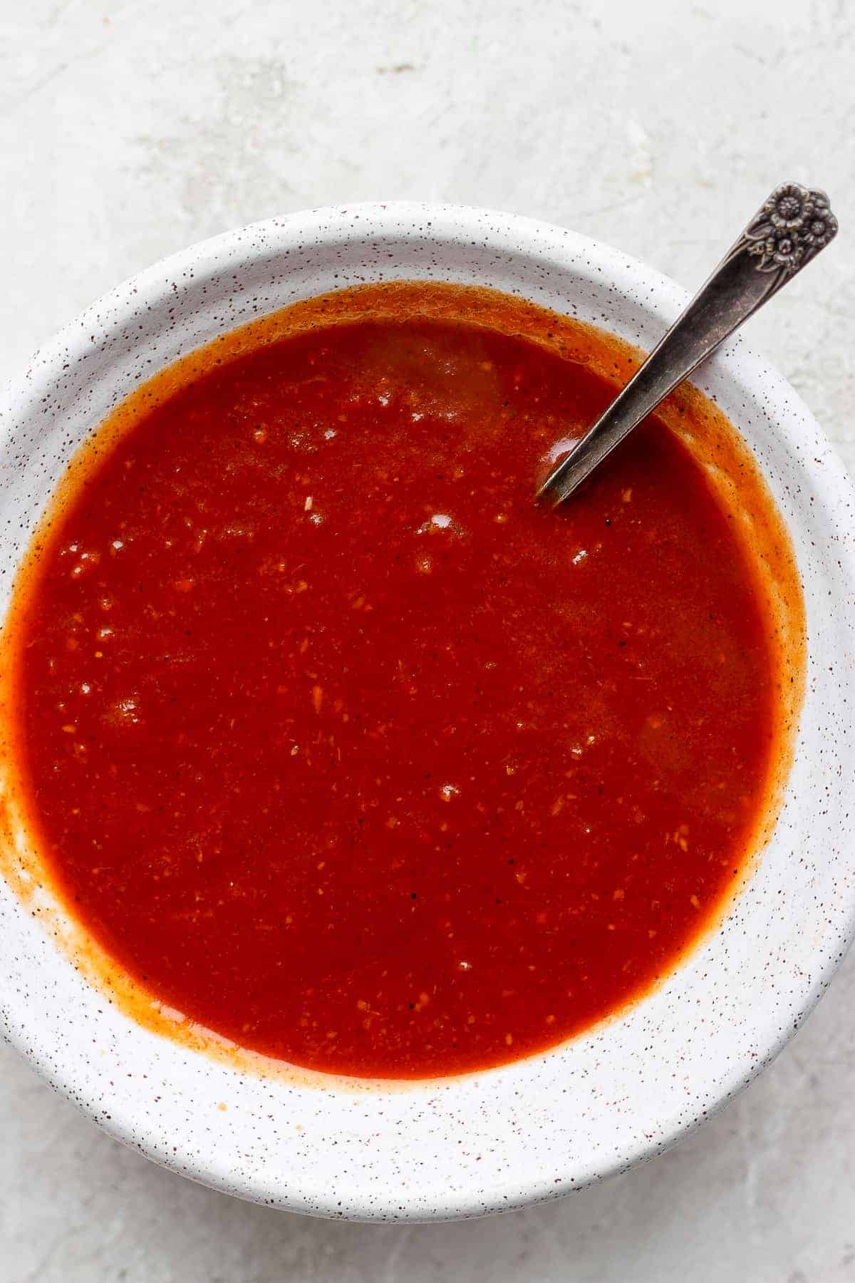 homemade BBQ sauce in a bowl with a spoon.