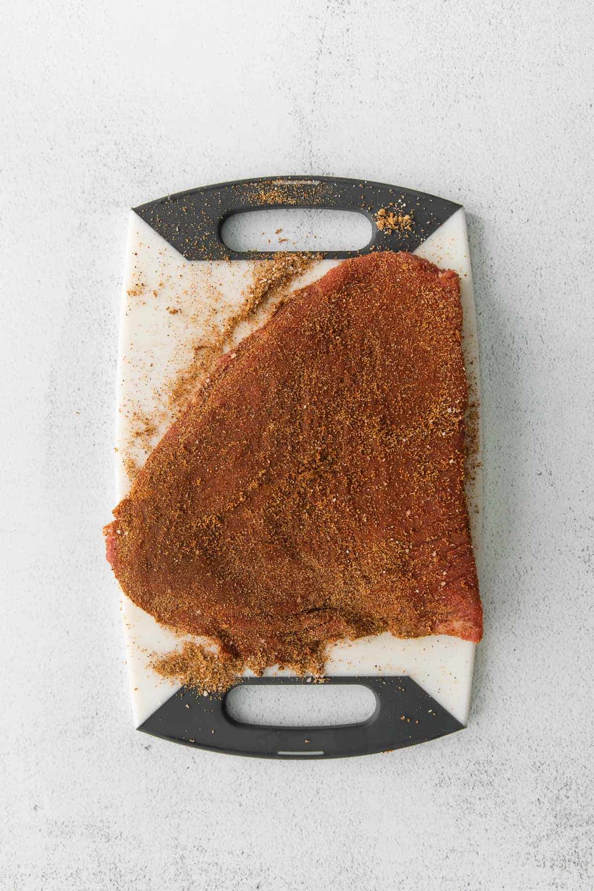 flank steak with steak taco seasoning dry rub on it