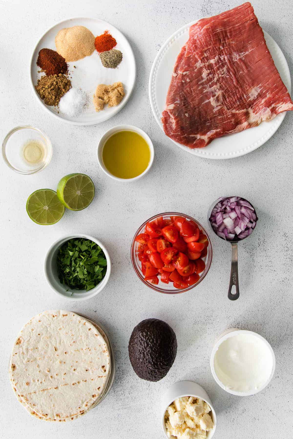 steak taco ingredients in bowls, ready to be mixed together for steak tacos