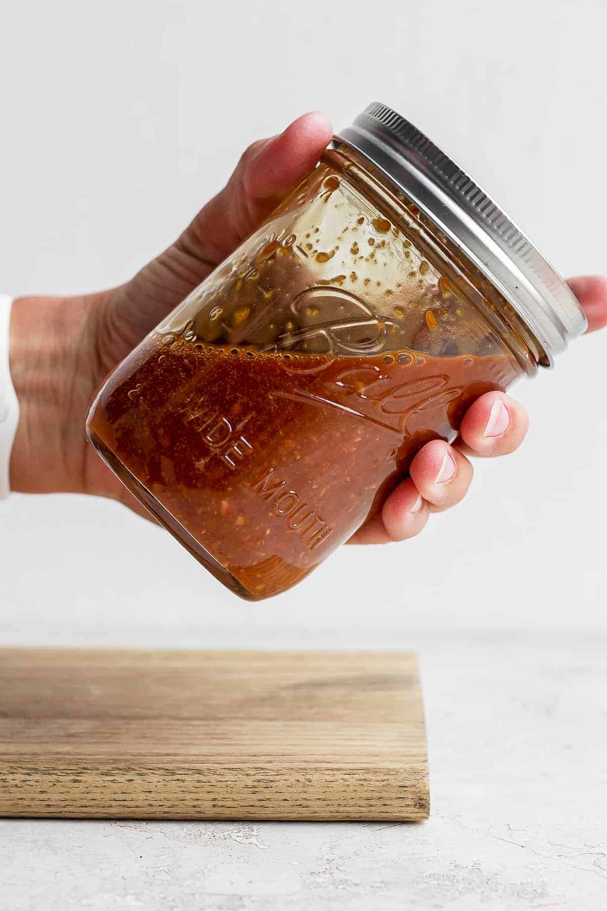 stir fry sauce in a mason jar in someone's hand being shaken 