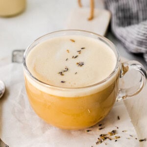 A cup of London fog lavender latte with a spoon on a napkin.