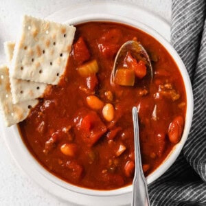 chili in bowl with crackers and a spoon.