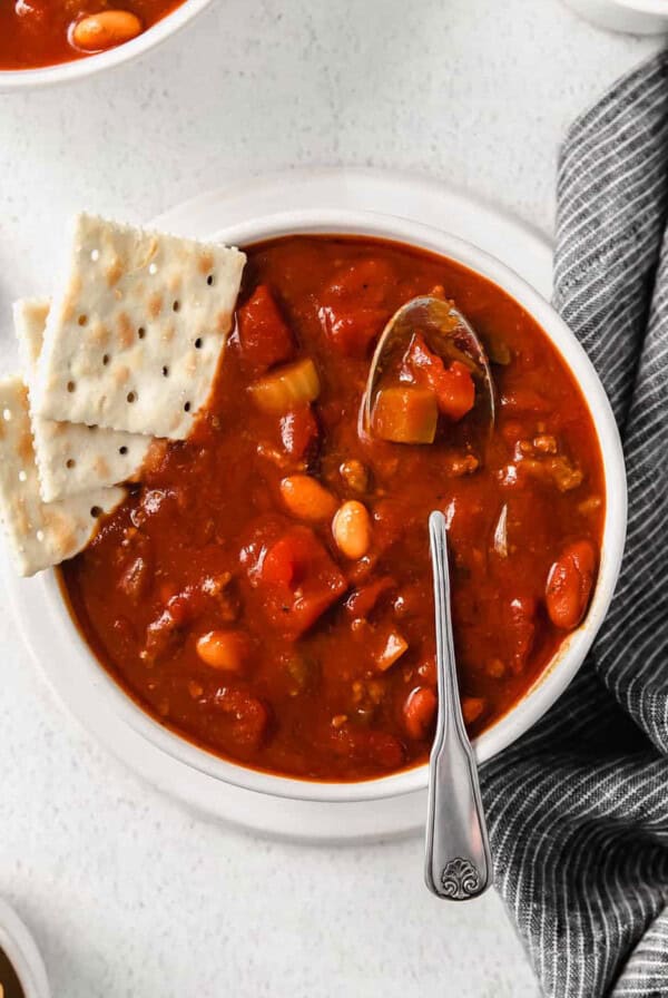 chili in bowl with crackers and a spoon.