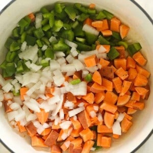 A vegetarian chili with onions and peppers in a white bowl.