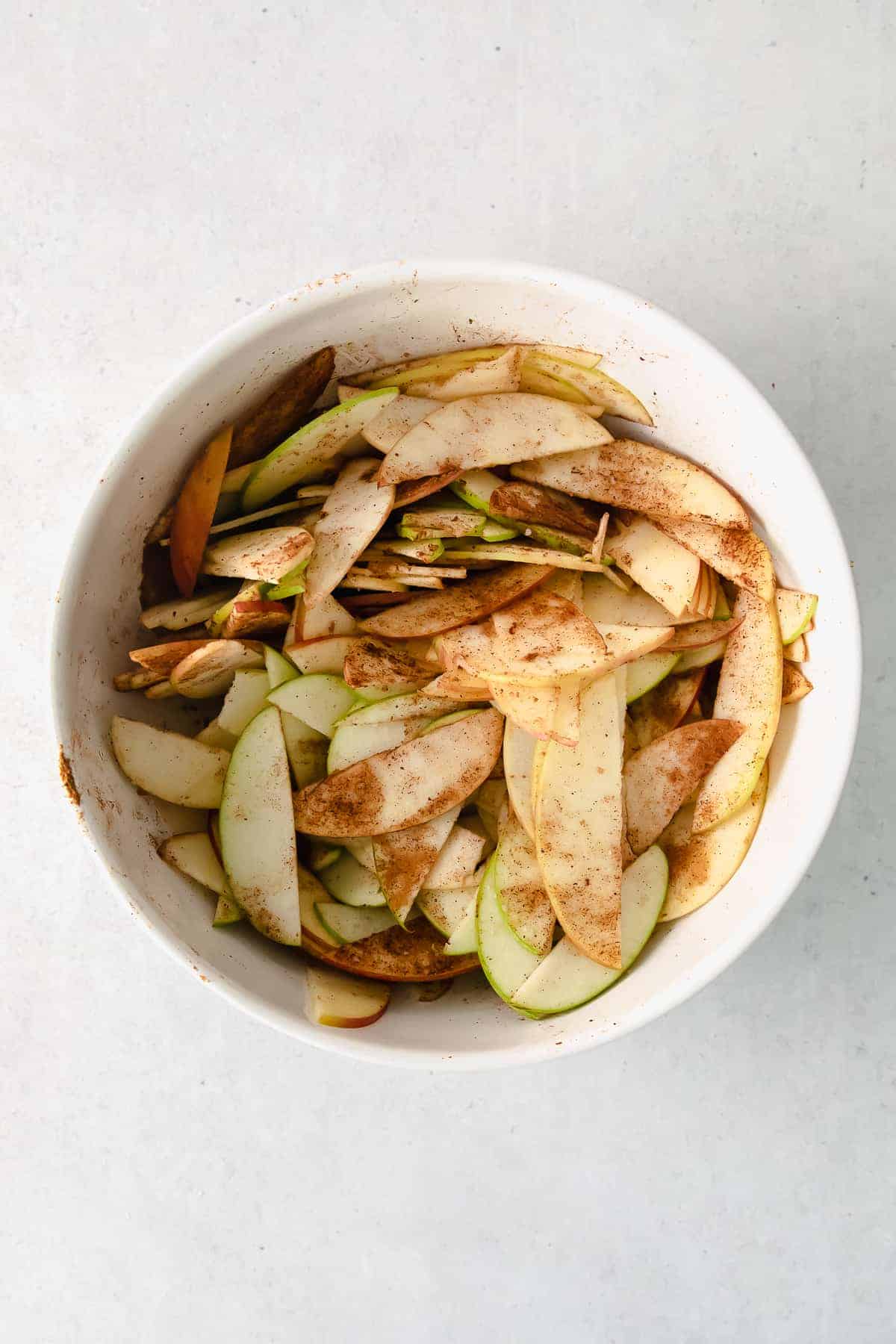 Apples in a bowl with warm spices mixed in. 