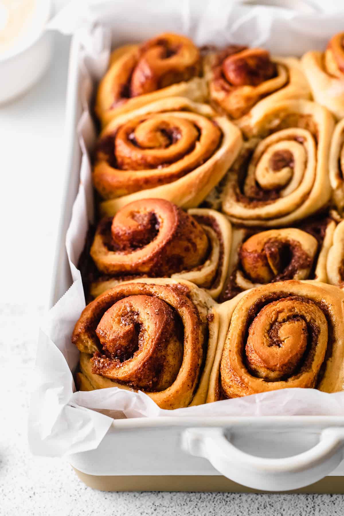 maple cinnamon rolls after being baked looking fluffy and amazing