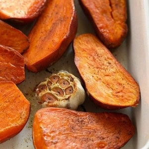 Roasted sweet potatoes in a green baking dish.