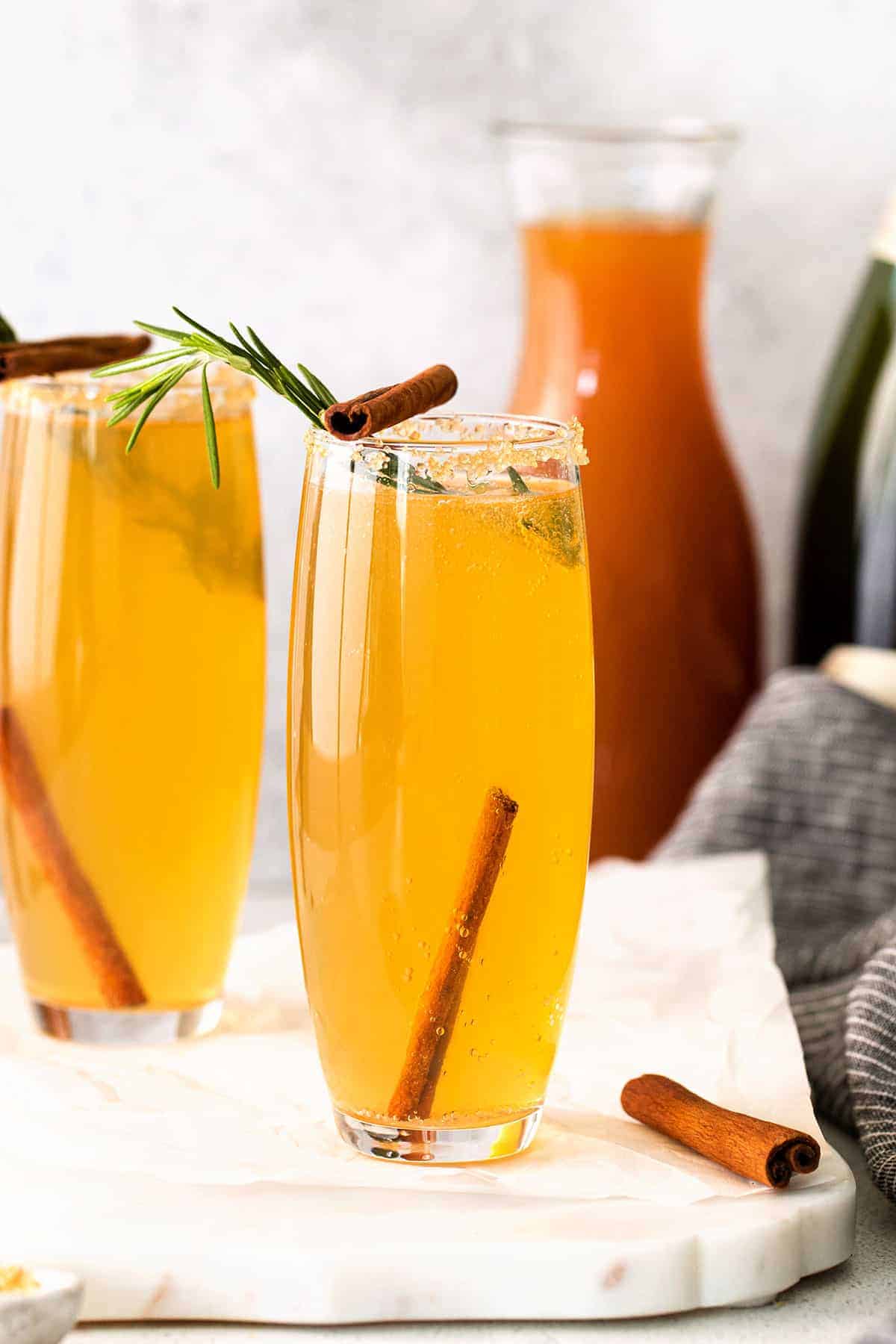 Apple cider mimosa garnished with cinnamon sticks.