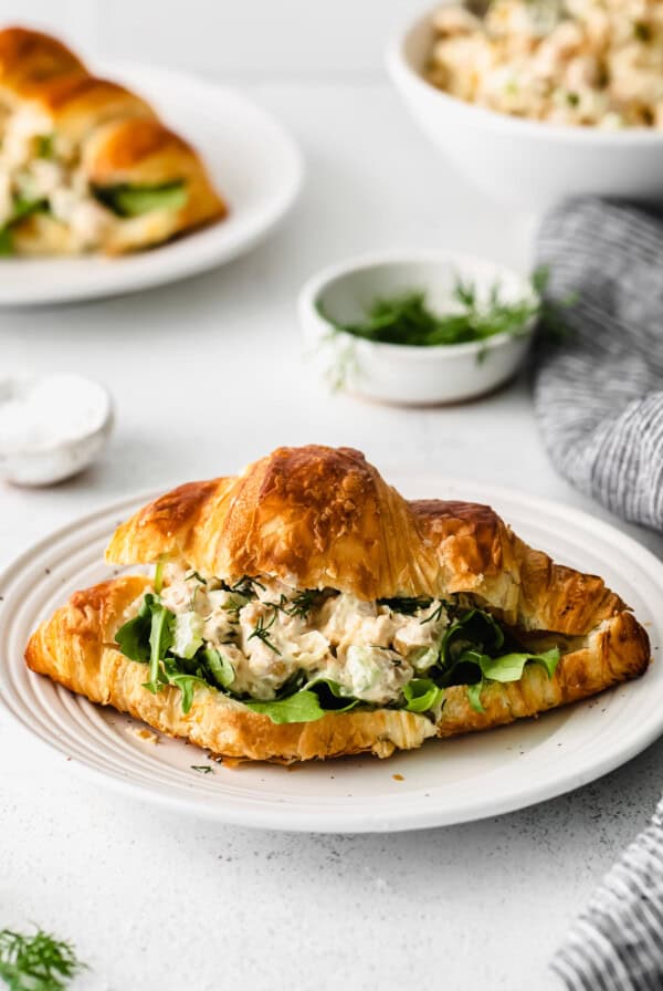 A croissant sandwich with tuna salad on a plate.