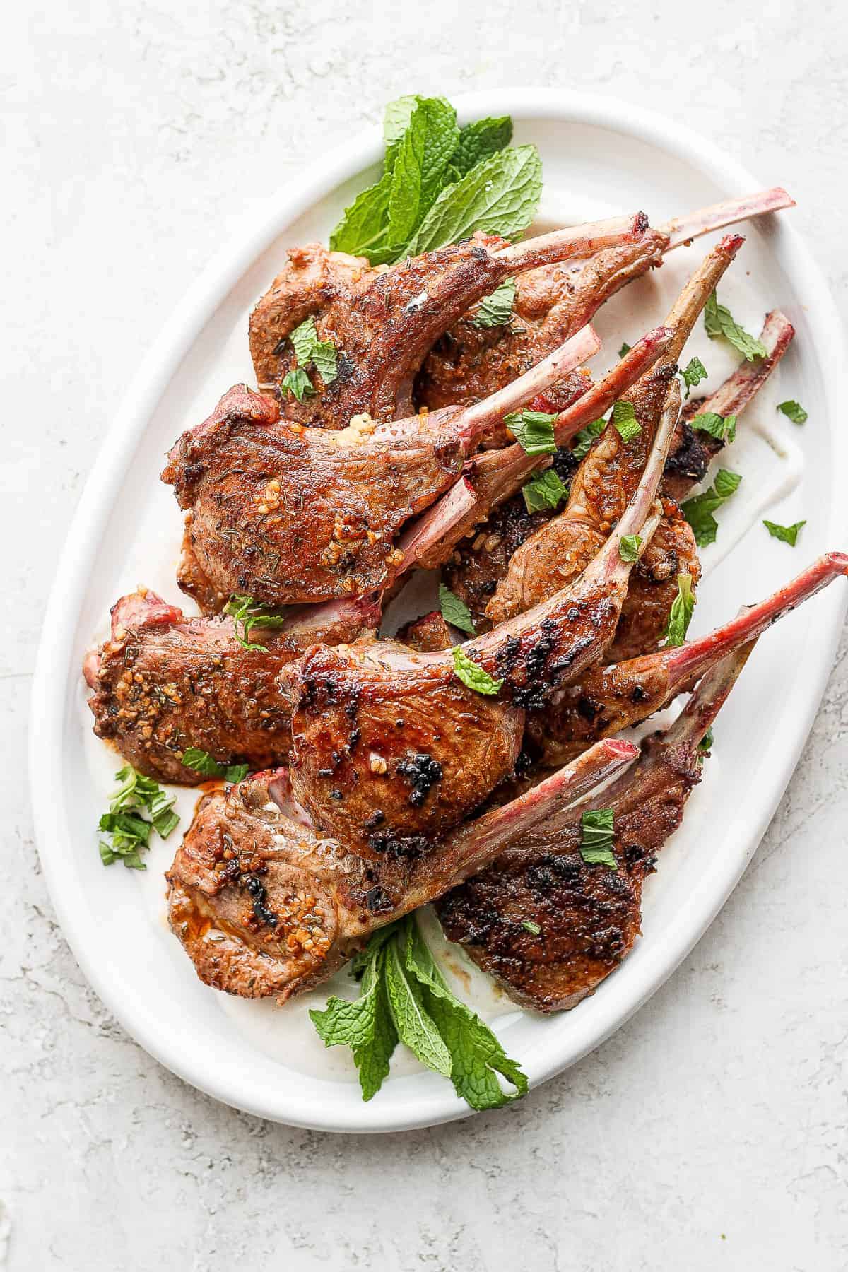 pan seared lamb chops on a plate garnished with fresh mint