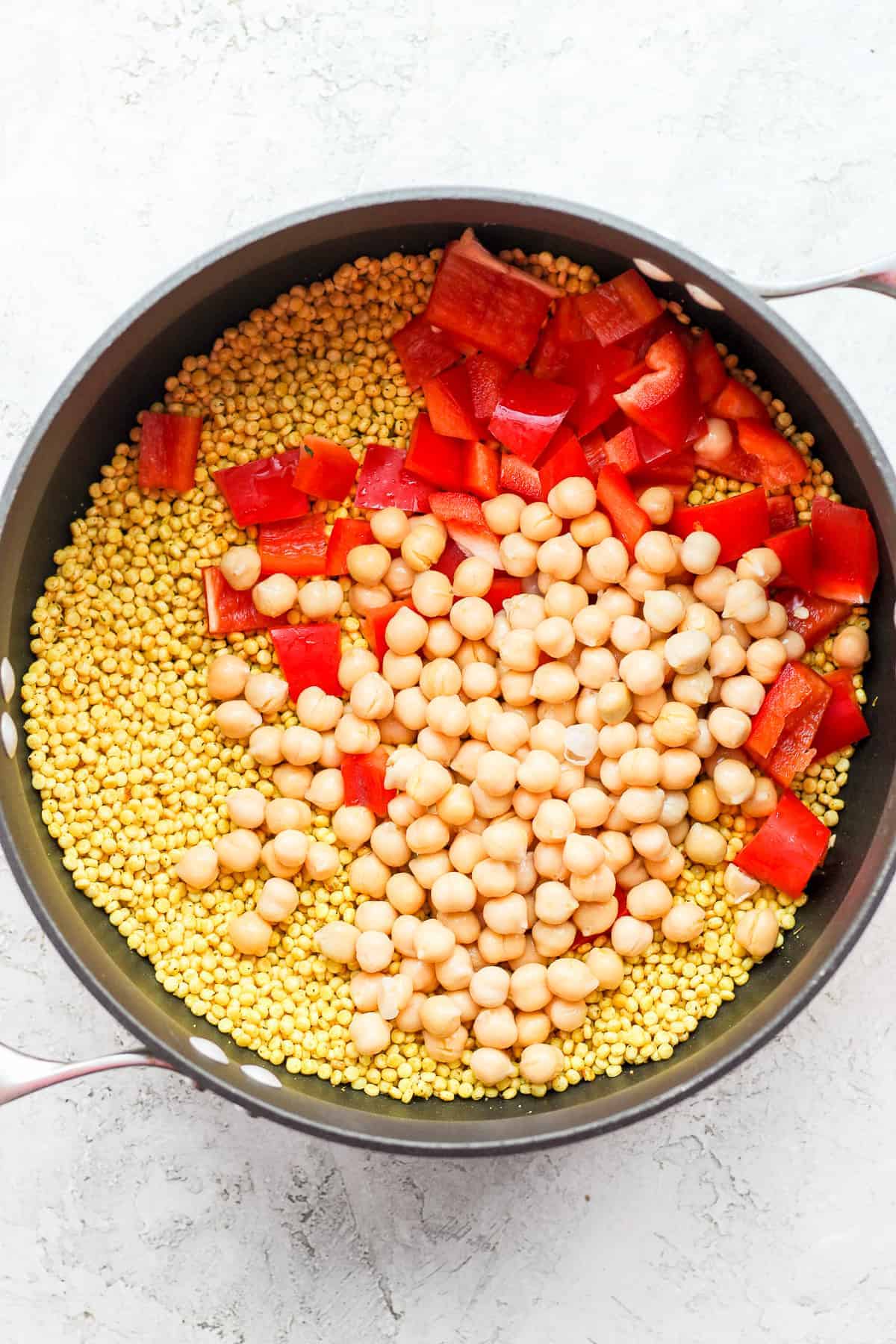 Red peppers, chickpeas, and couscous in a pot. 