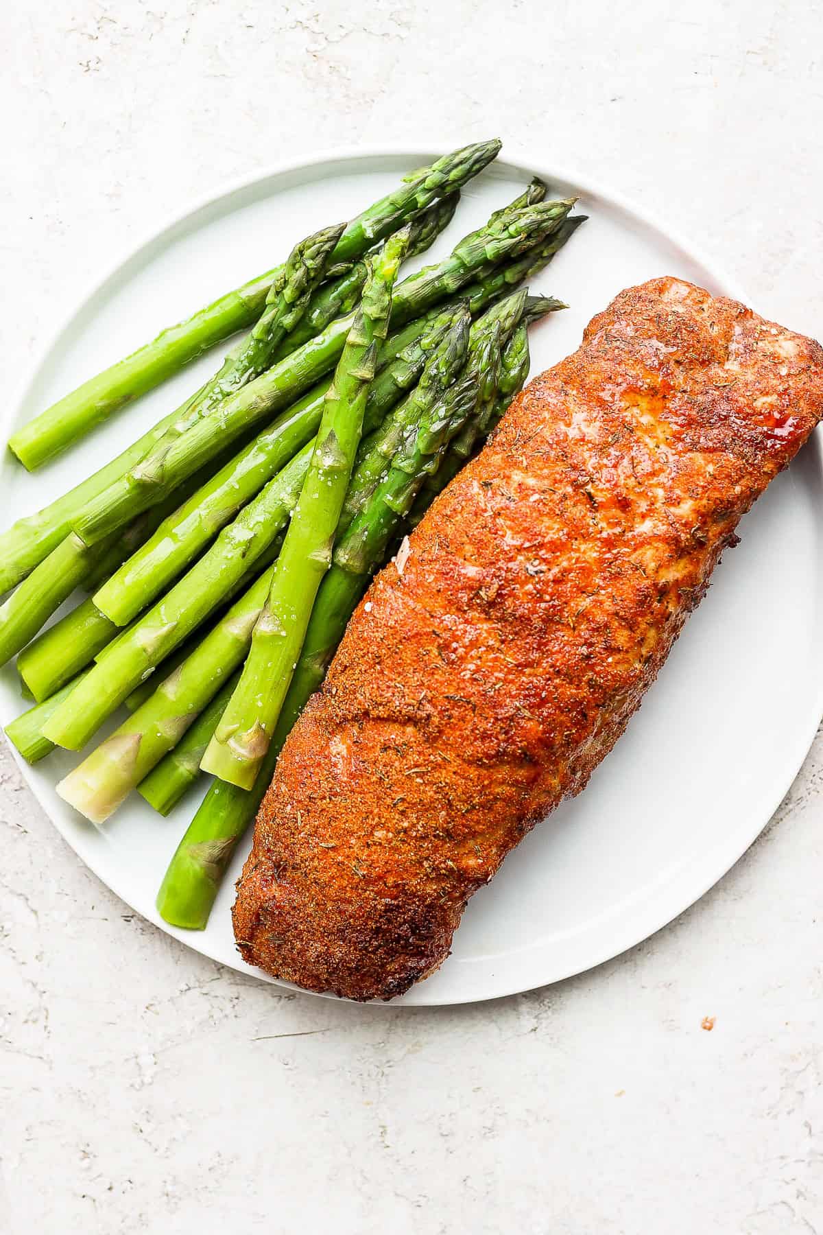 air fryer pork tenderloin on a plate with asparagus 