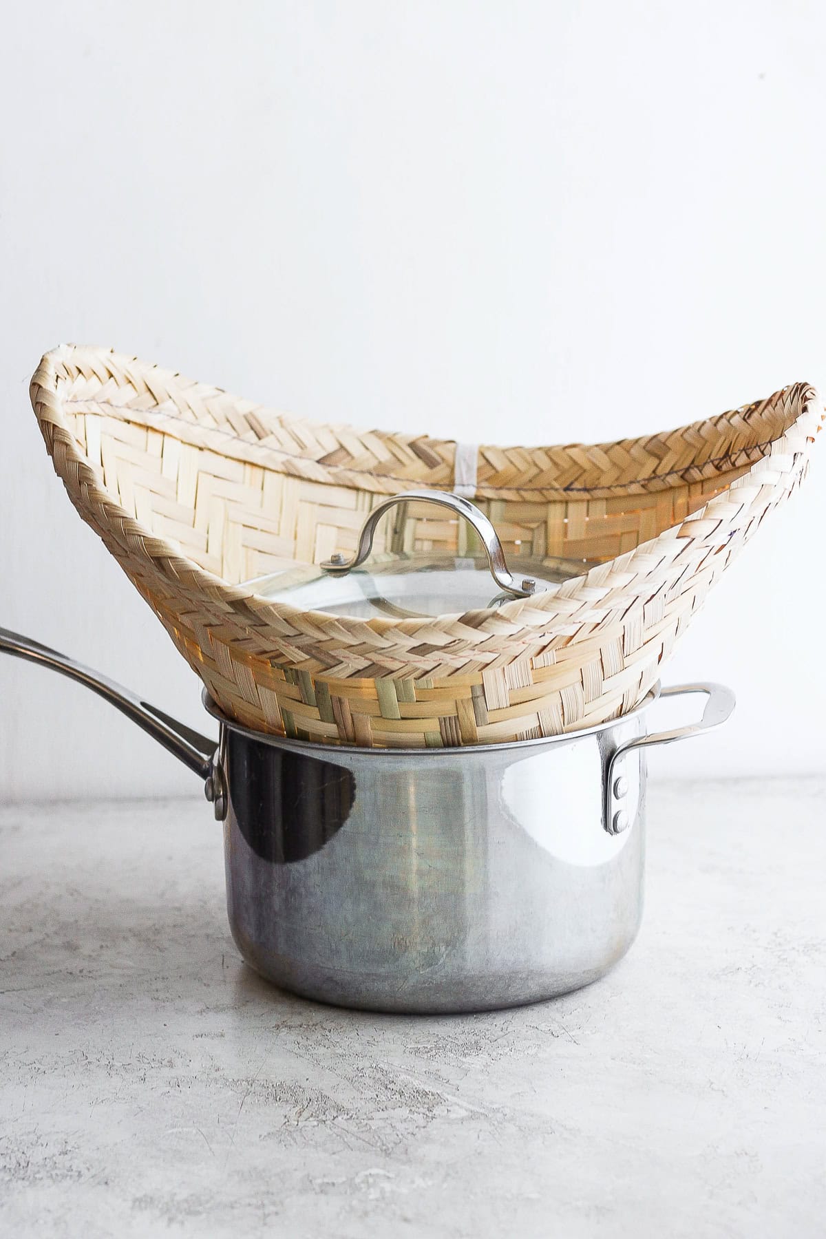 sticky rice being steamed in a pot with a bamboo basket