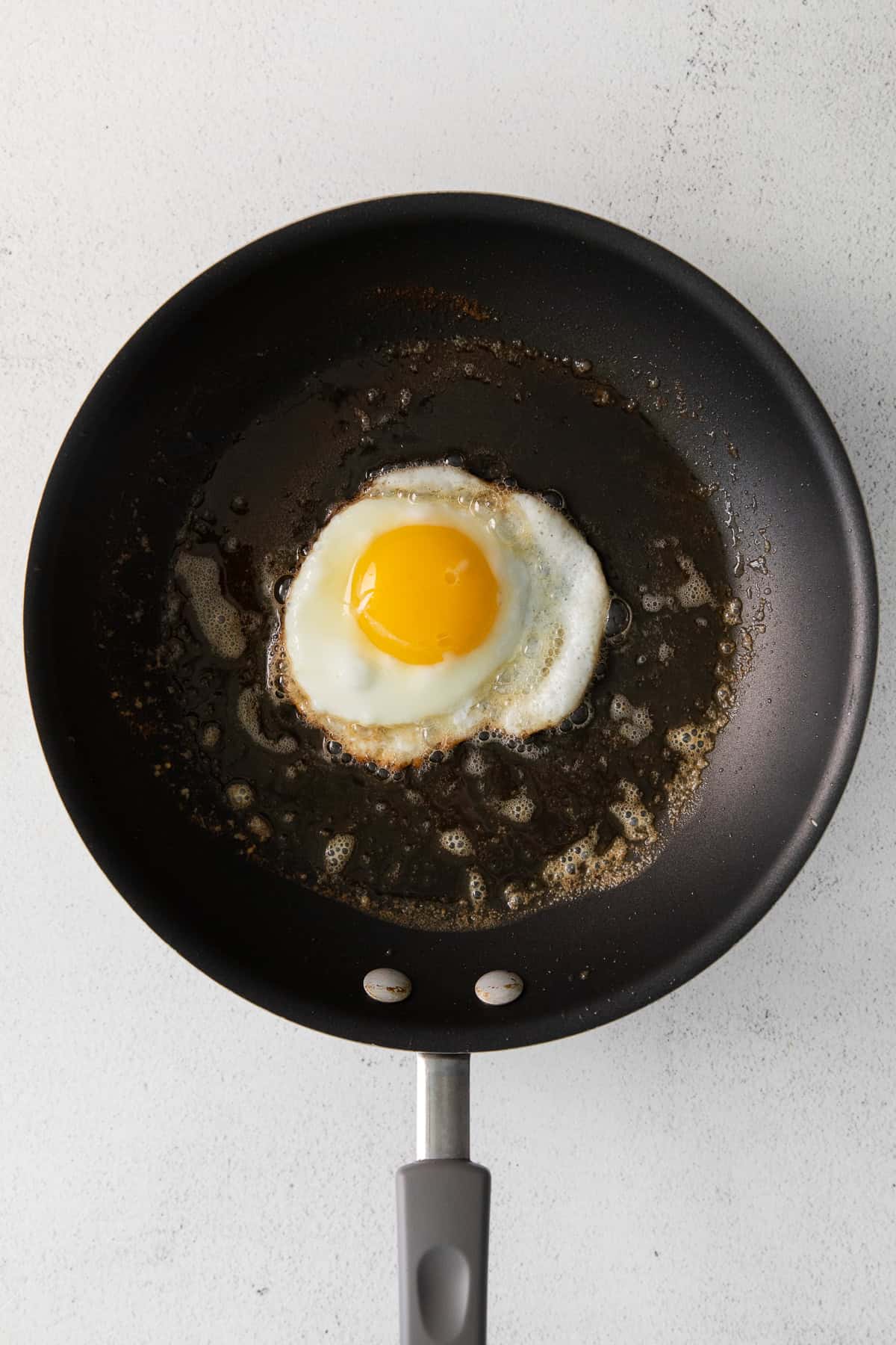 Fyring an egg in butter in a nonstick pan. 